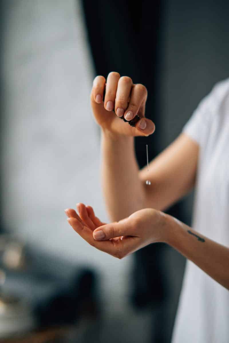 A Person Pouring Massage Oil on a Hand